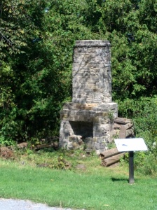 A picture of the ruins of the old kitchen. The stove and chimney are still standing, but the rest of the kitchen has been destroyed.